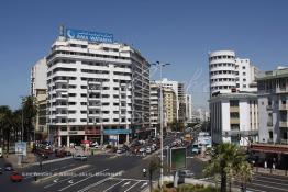 Image du Maroc Professionnelle de  Dans les années 50 apparaît le nouveau quartier d’affaire de Sidi Belyout, construit dans un style jusque-là inconnu. Son exécution était prévue par un plan d’ensemble d’Ecochard, approuvé en 1952.L’Avenue des Forces Armées Royales (F. A. R.)., à gauche, représente l’une des plus grandes réussites de ce projet. Bordée d’une suite de hauts immeubles d’un aspect très agréable et bien entretenus, elle bénéficie également d’un élargissement spatial considérable, dû à l’originalité architecturale de ses constructions en biais (la rangée du milieu), Mardi 7 Juillet 2009. (Photo / Abdeljalil Bounhar) 